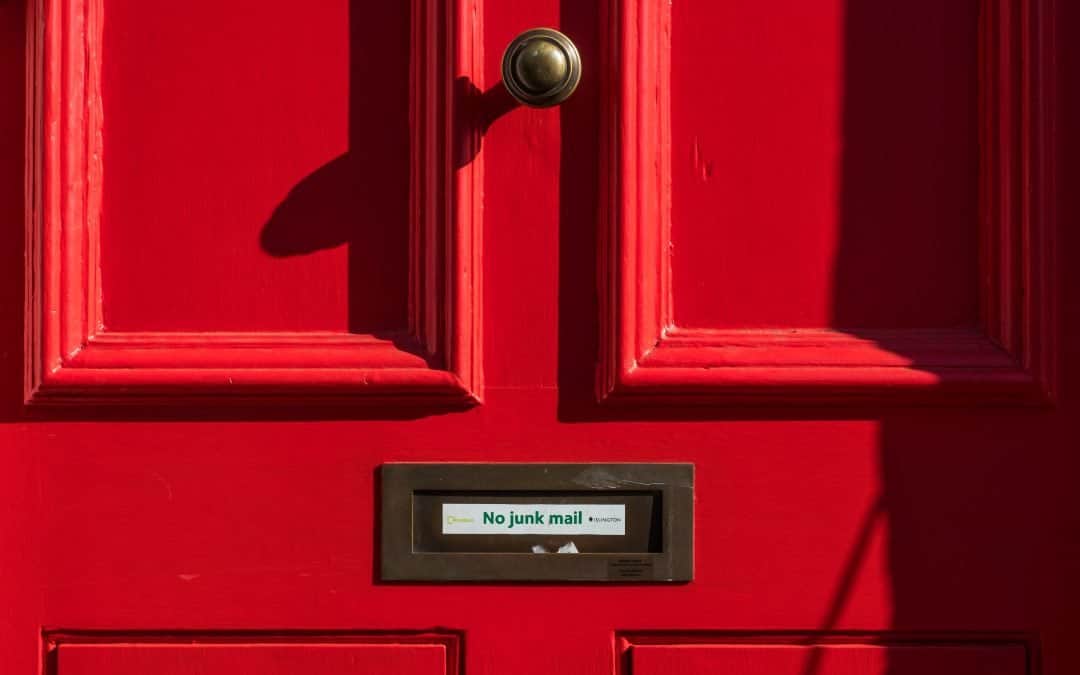 Red door with letter slot that says "no junkmail"
